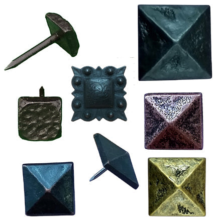 A photo of 7 different square clavos door nails with distressed surfaces.