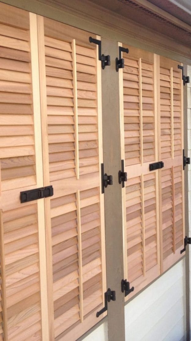 Matte black L style hinges installed on wood window shutters