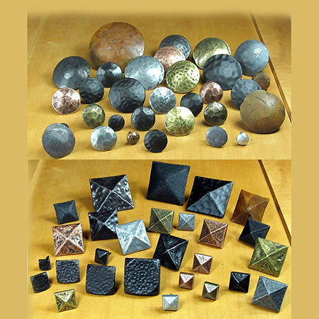 An assortment of square and circular clavos door pins in silver, brass, black, and hammered finishes.