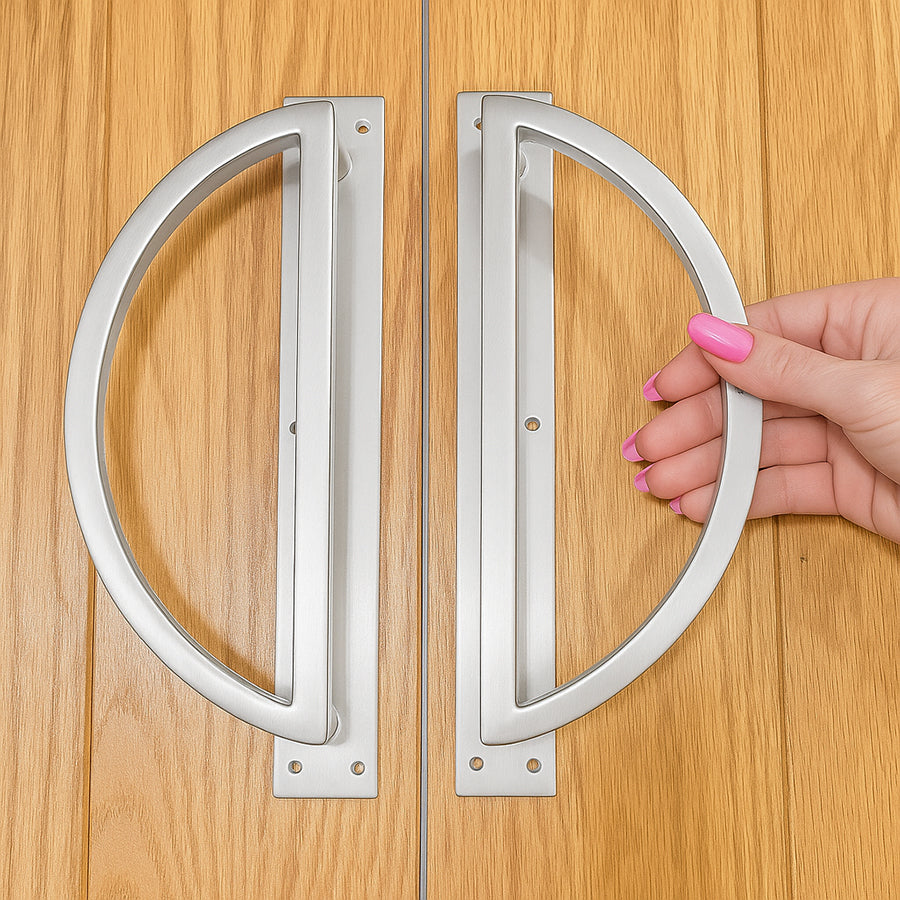 circular door handles on a wooden door with a hand holding one handle.