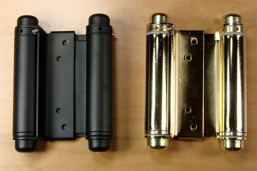 Double action spring hinges measuring 4 inches and available in matte black and brass finishes, displayed on a white background.