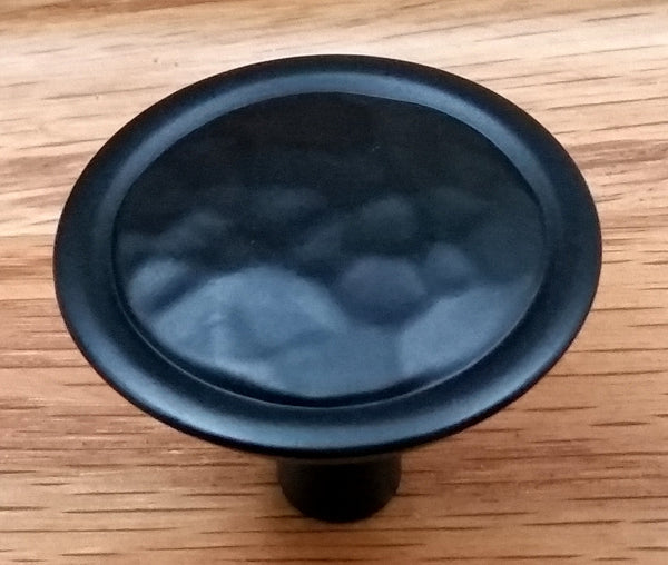Black knob with hammered texture design.