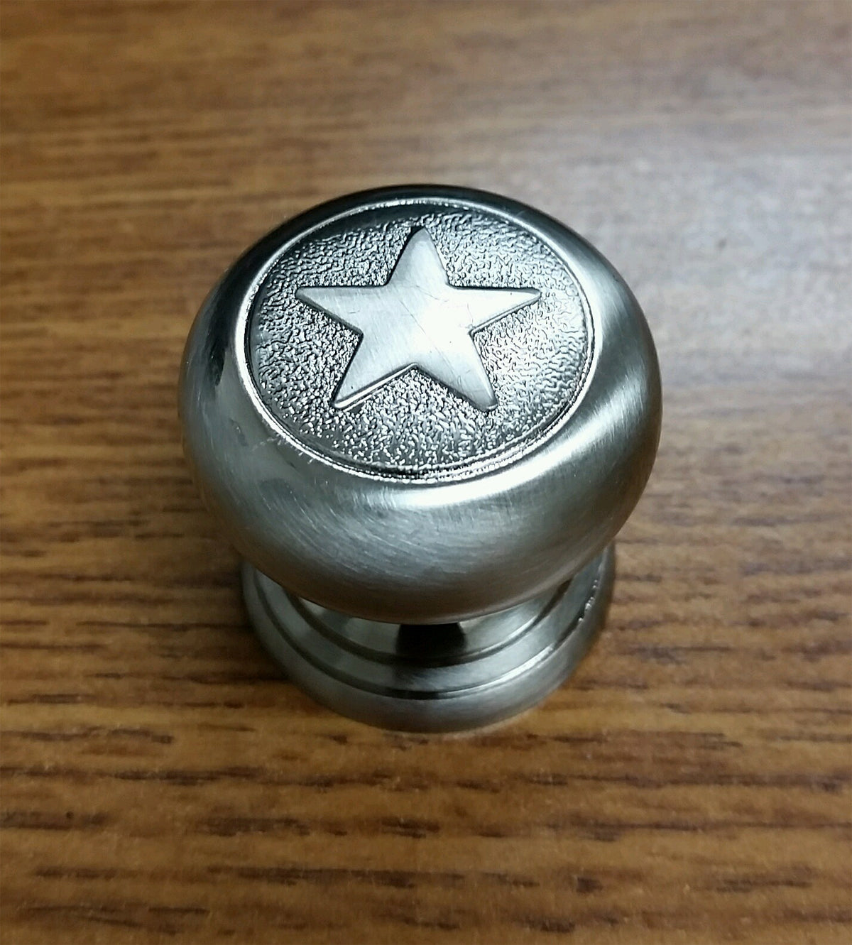 A top-down view of a star-shaped knob, used as a decorative drawer or cabinet pull, displayed on a white background.