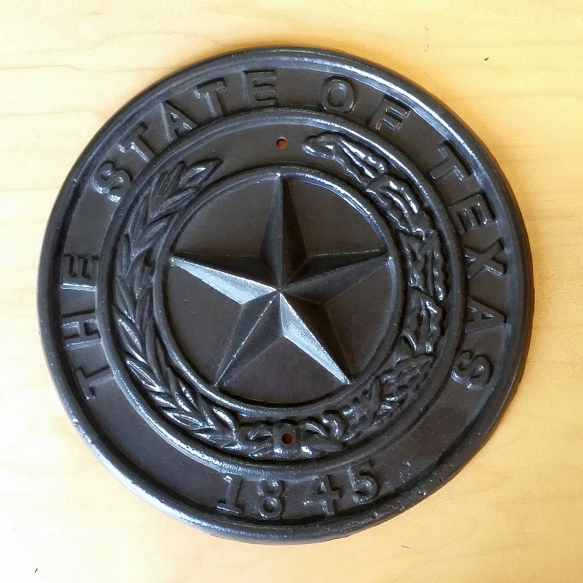 A Texas plaque made of metal, used as a decorative item, displayed on a white background.